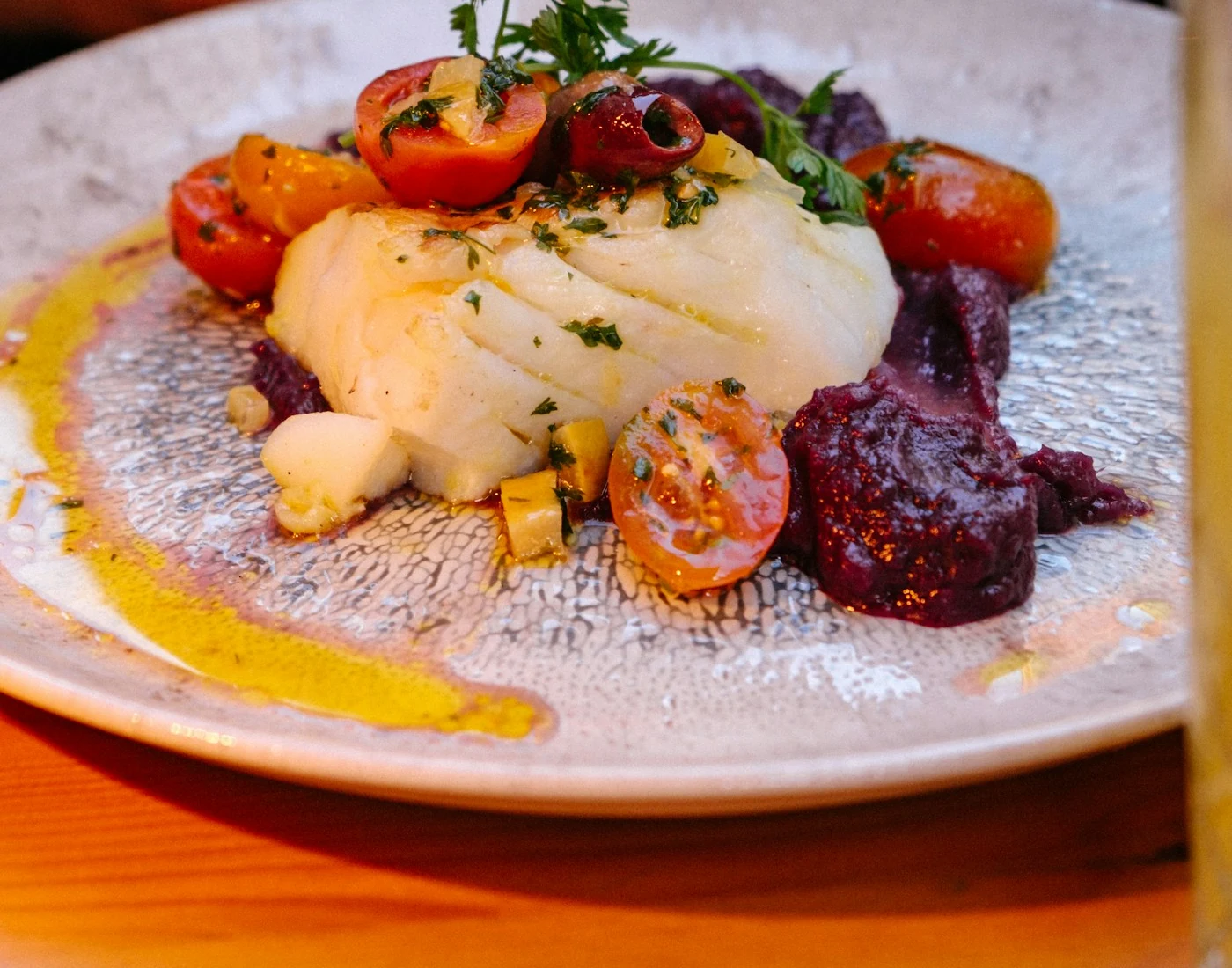 Filet de poisson blanc cuit, tomates et légumes. Photographie d’illustration.